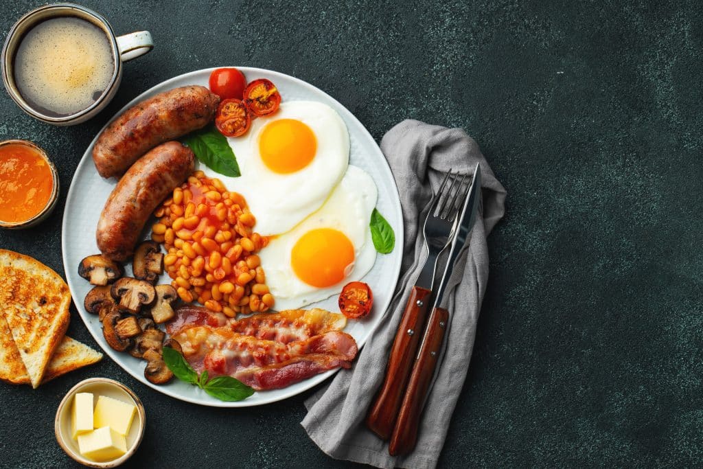 Full English breakfast on a plate with fried eggs
