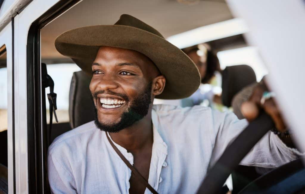 Happy, taxi and driver with black man driving and enjoying career, safari tour guide in vehicle. Ad