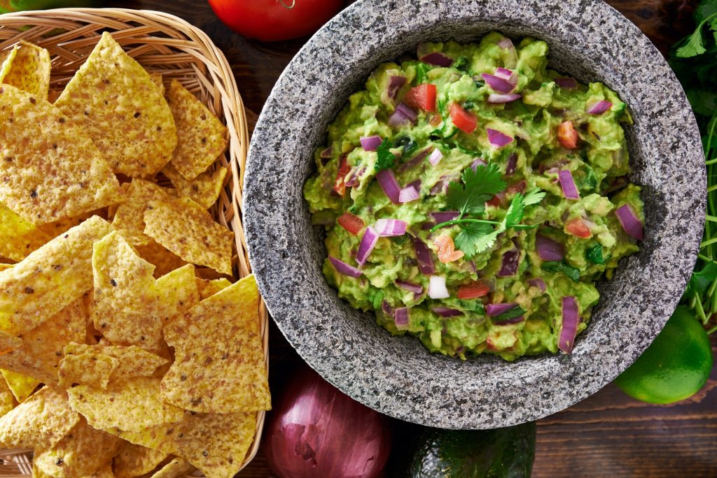 mexican guacamole in molcajete with tortilla chips
